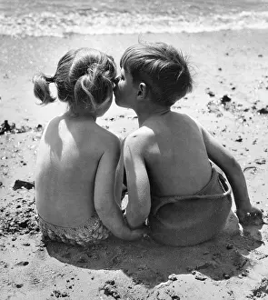 Pigtails: Two children sitting on a beach