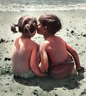 Pigtails: Two children sitting on a beach