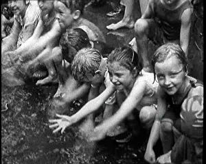 Heatwave: Children Splashing In Water in the Gutter During