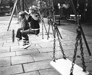 Matting: Two children on swings in a playground