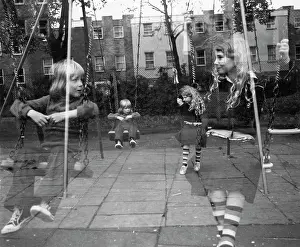 Krish: Two children on swings in a playground