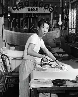 Ferrous: Chinese Laundry Man Looking at Camera Ironing Clothes on B