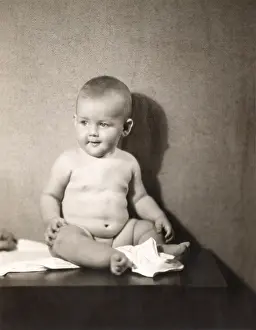 Diaper: Chubby baby boy sitting on table with diaper off