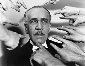 Chastise: Closeup of many fingers pointing at man