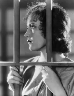 Hopelessness: Closeup of woman behind bars