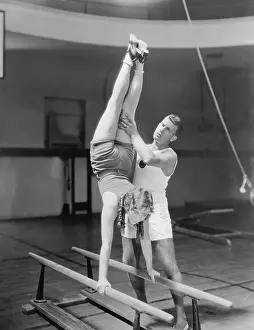 Handstand: Coach helping woman on parallel bars