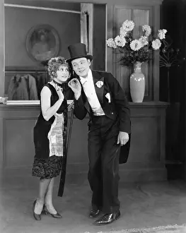 Formalwear: Coat clerk whispering to a man in a top hat