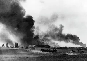 German Soviet: Column of the Wehrmacht passing by a burning village on the