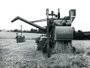 Gleaning: Combine harvester at work in a field, Cornwall