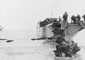 Bicycles: Commandos wade ashore from landing craft at Juno beach