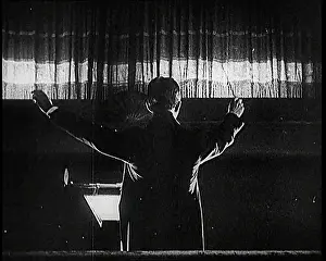 Raises: Conductor and Orchestra Performing As the Curtain Raises