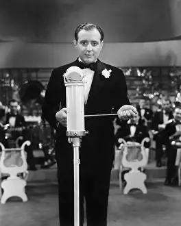 Formalwear: Conductor standing in front of his orchestra with a baton