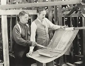 Analyzing: Construction worker going over plans with architect