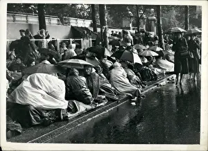 Huddle: Coronation spectators in the rain on Coronation eve