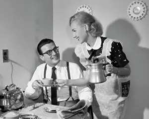 Couple at Breakfast Table Man Reading Newspaper Smiling a