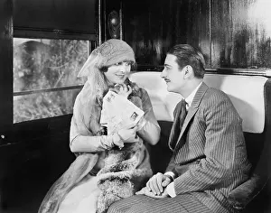 Intimacies: Couple in a compartment of a train looking and talking