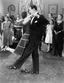 Flirtatious: Couple dancing lightly while others are watching