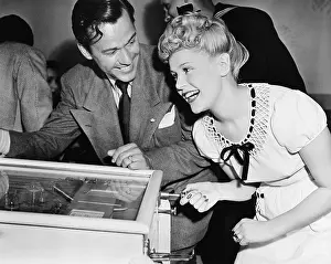 Chuckling: Couple having fun and laughing next to a pinball machine