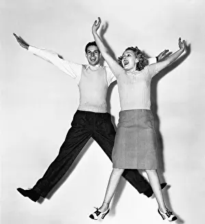 Mid Air: Couple jumping with their arms outstretched
