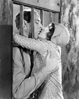 Tenderness: Couple kissing through bars of jail cell