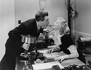 Workplaces: Couple kissing in the office