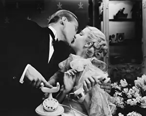 Interrupting: Couple kissing with telephone