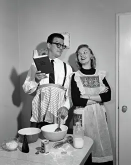 Reversal: Couple in kitchen with husband learning to cook