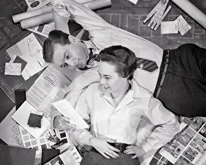 Blueprints: Couple Lying on Top of Blueprints Samples for New Home