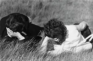 Propped: Couple lying on the grass in a park