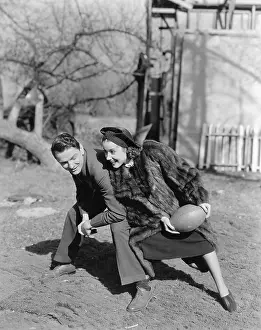 Chuckling: Couple playing football with each other