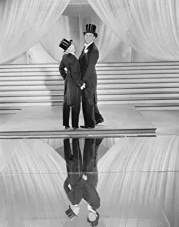 Dressers: Couple posing in tuxedos and reflection