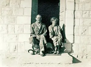 Sepia Images: Couple in pyjamas sitting on a stone step in the sun