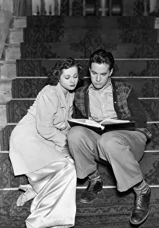 Educate: Couple reading together on stairs