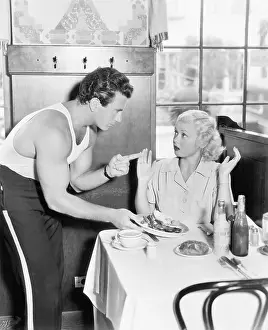 Argue: Couple in a restaurant having an argument over food