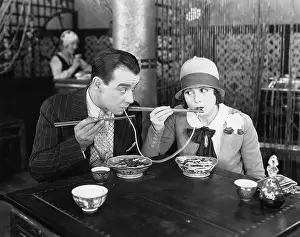 Foodstuff: Couple sharing a noodle in a restaurant
