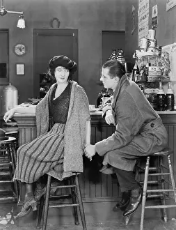 Coquettish: Couple sitting together at a bar looking at each other