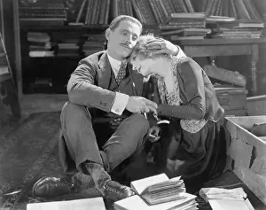 Mustaches: Couple sitting on the floor of a library holding each other