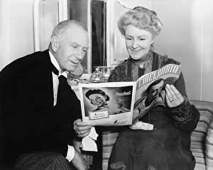 60 65: Couple sitting together and looking at a magazine