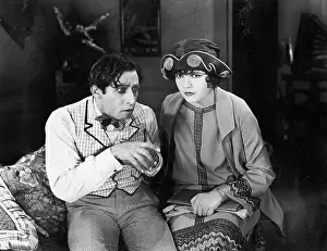 Side By Side: Couple sitting together on a sofa looking worried