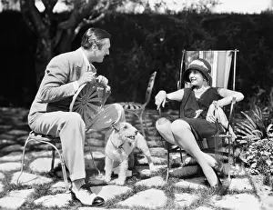 Flirtatious: Couple sitting in the back yard talking with a dog