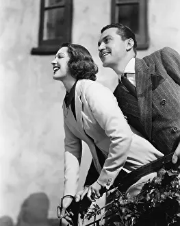 Joyous: Couple standing at a balcony and smiling