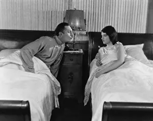 Smooching: Couple in twin beds