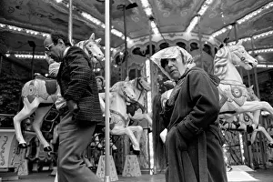 Oosterbroek: A couple walk past a fairground carousel