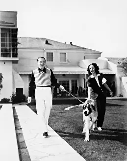 20 25: Couple walking their St. Bernard outside their home