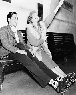 Joyous: Couple wearing roller skates and sitting on a bench