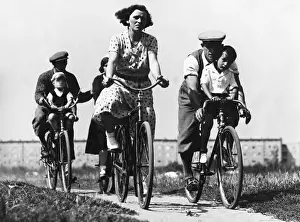 Hobby: Two couples with children on bicycles, 1930s