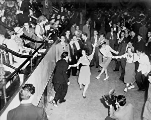 Jitterbug: Couples jitterbug dancing on a dance floor, ?
