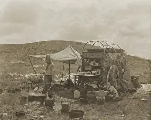 Lcgr1803: A cowboy cooks at a chuck wagon, getting dinner