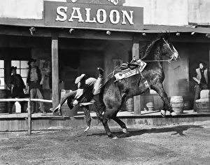 Bucking: Cowboy being thrown off his horse