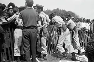 Enforcement: A crowd of African Americans behind a fence